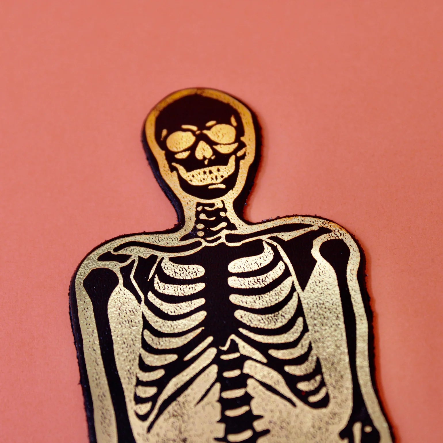 Skeletal figure on a pink background.
