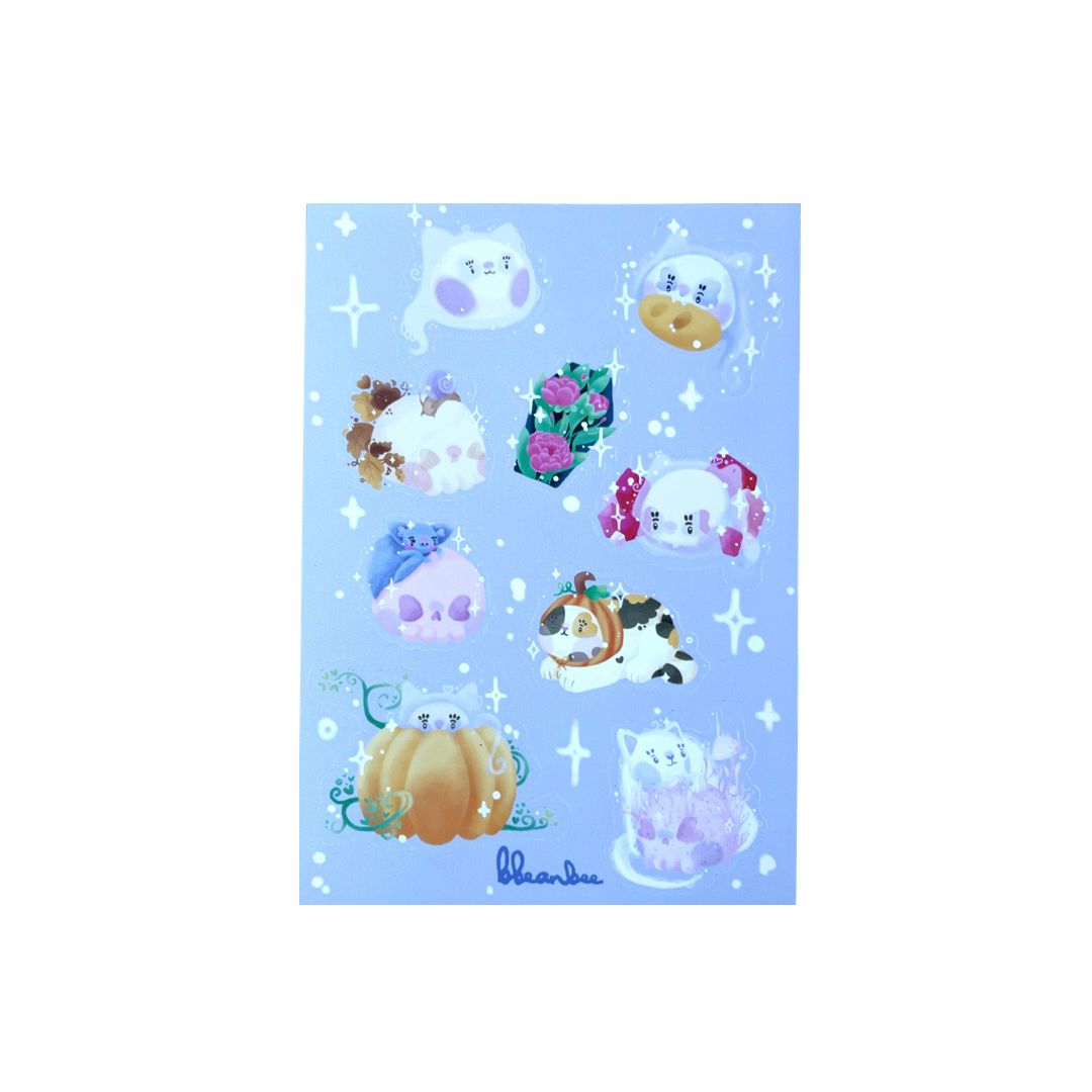 Handmade vinyl sticker sheet with nine Halloween and lightly spooky stickers, on a light purple background. Including, pumpkins, cat ghosts, heart skulls, and crystals. 