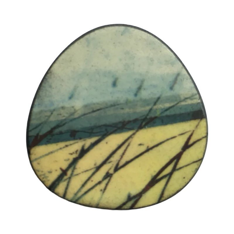 This porcelain oval brooch is made from black porcelain casting slip layered with a white decorating slip and a ceramic decal.