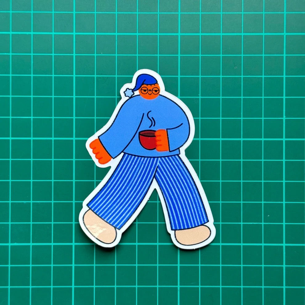 Illustration of a person wearing blue pajamas holding a red cup on a green background.