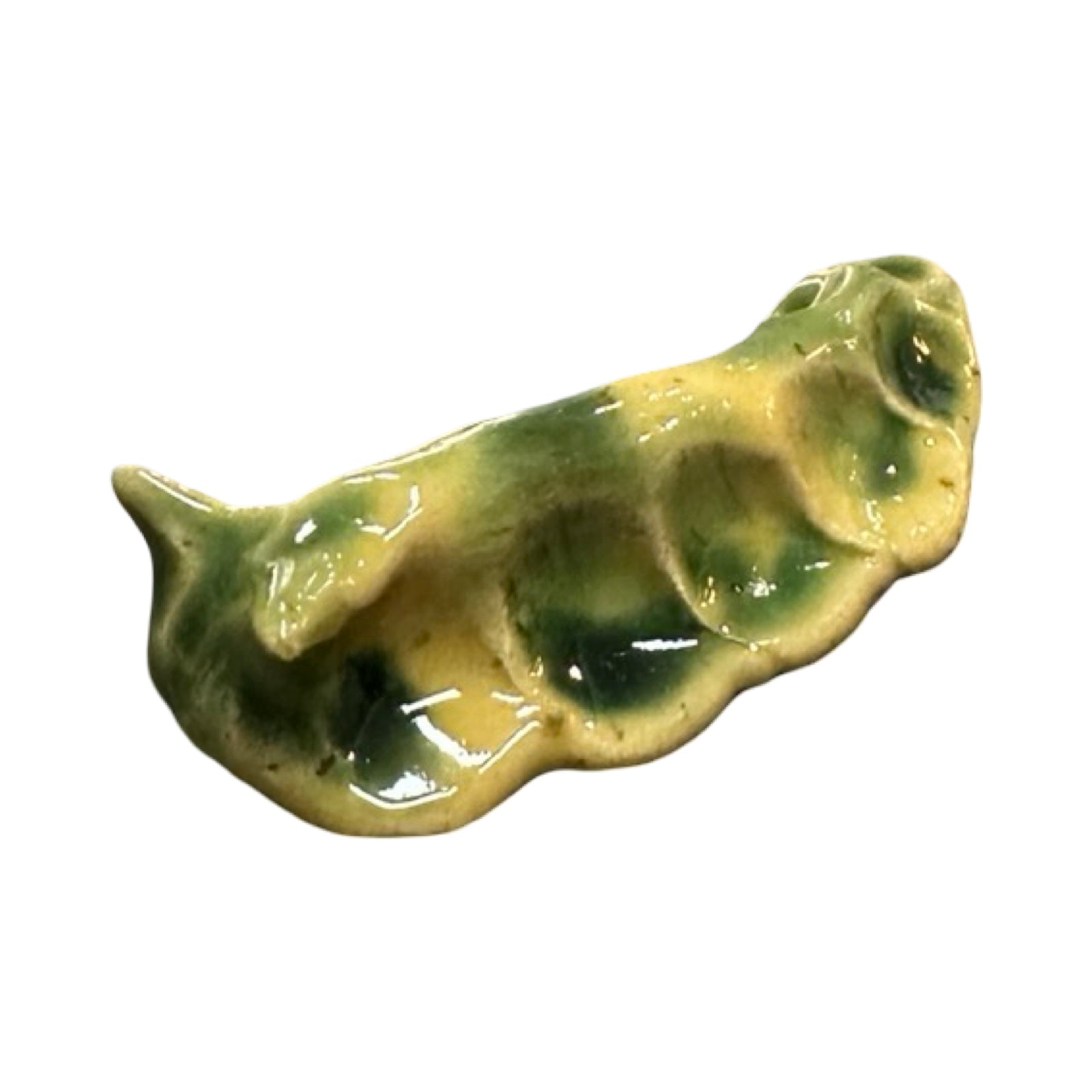 Ceramic slug ornament green and yellow glaze on a white background.