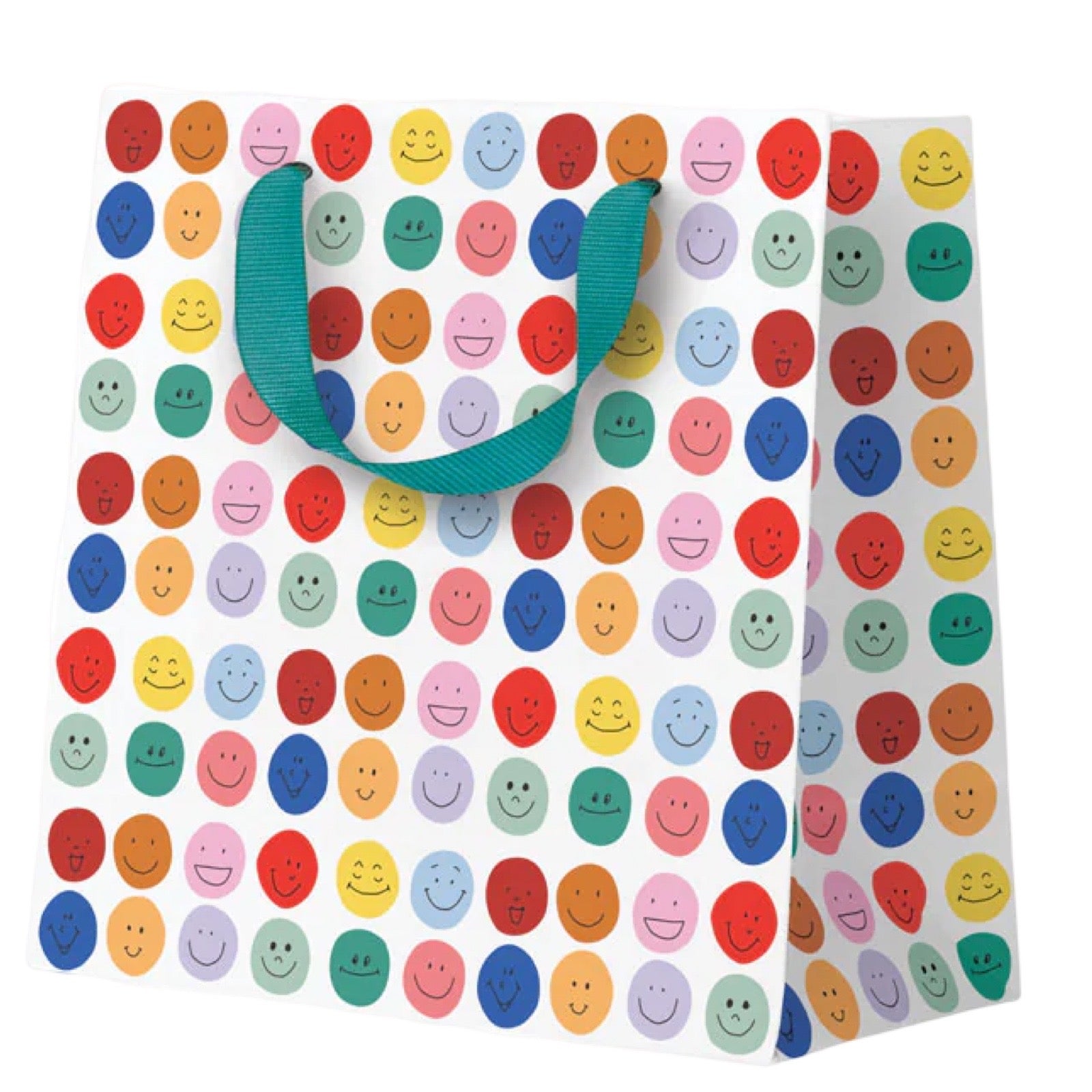 A white gift bag covered in a colourful pattern of smiling face circles in various colors, with teal ribbon handles, shown on a plain white background.