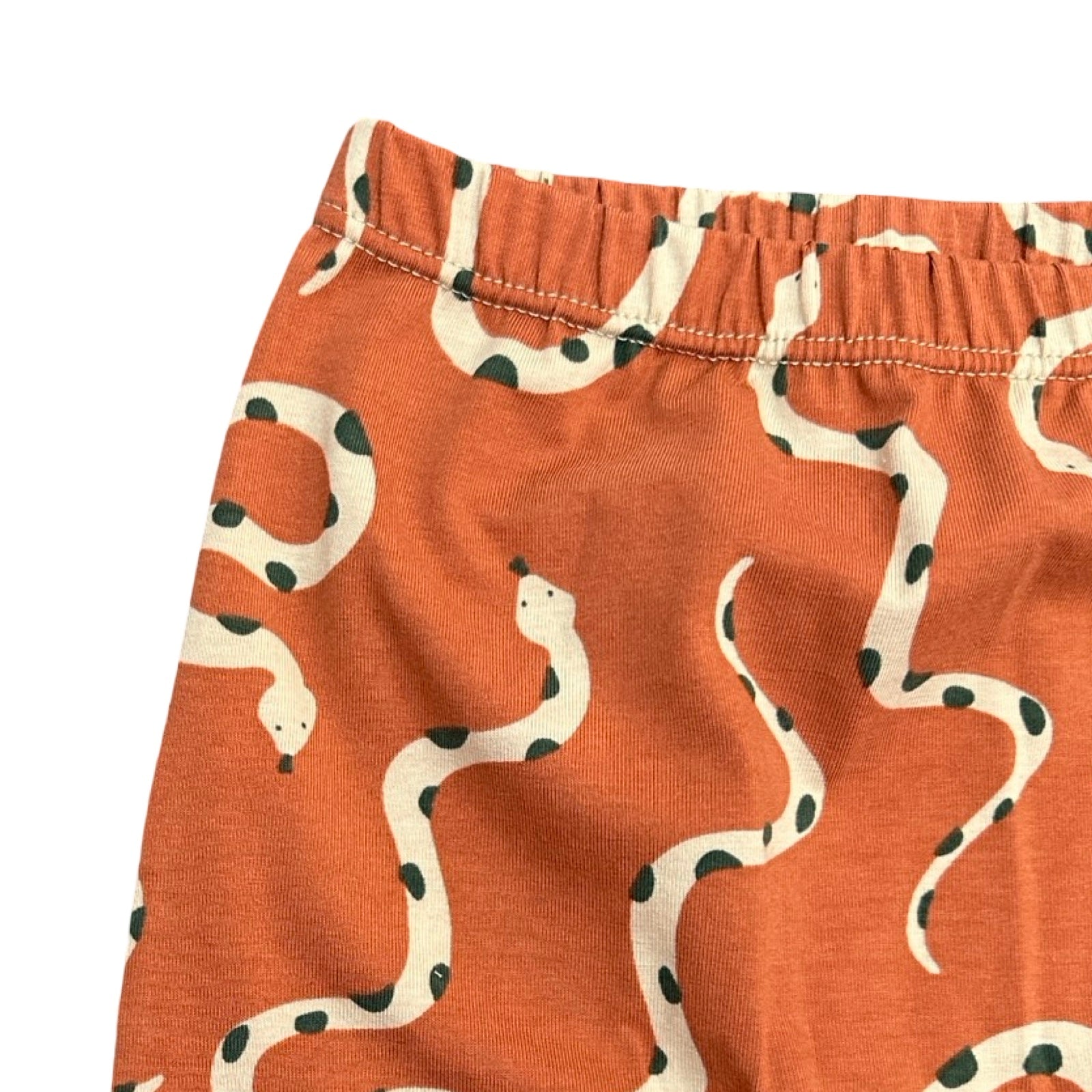Orange shorts with snake pattern on a white background.