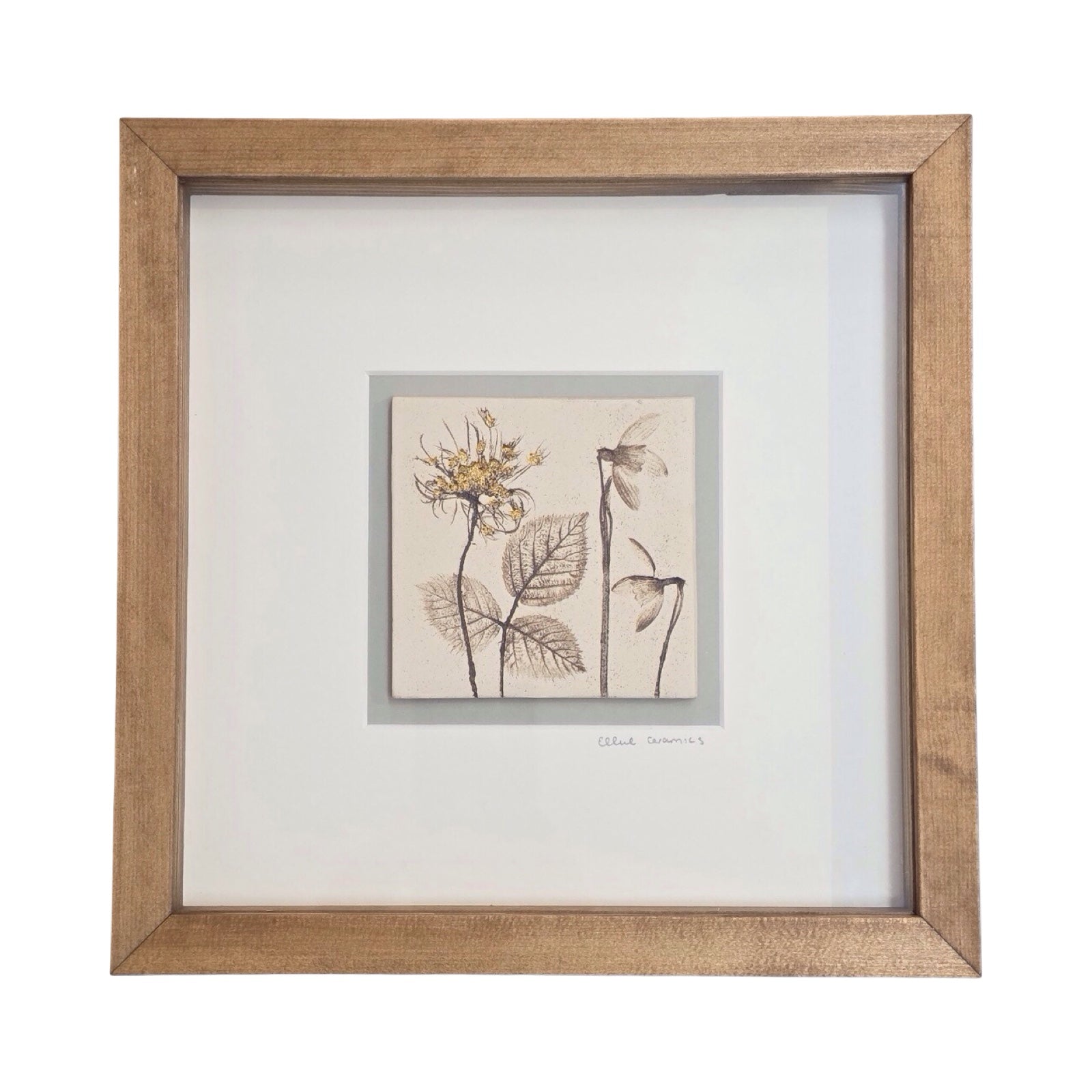 Framed single botanical tile with snowdrops and wild carrot in a oak frame on a white background