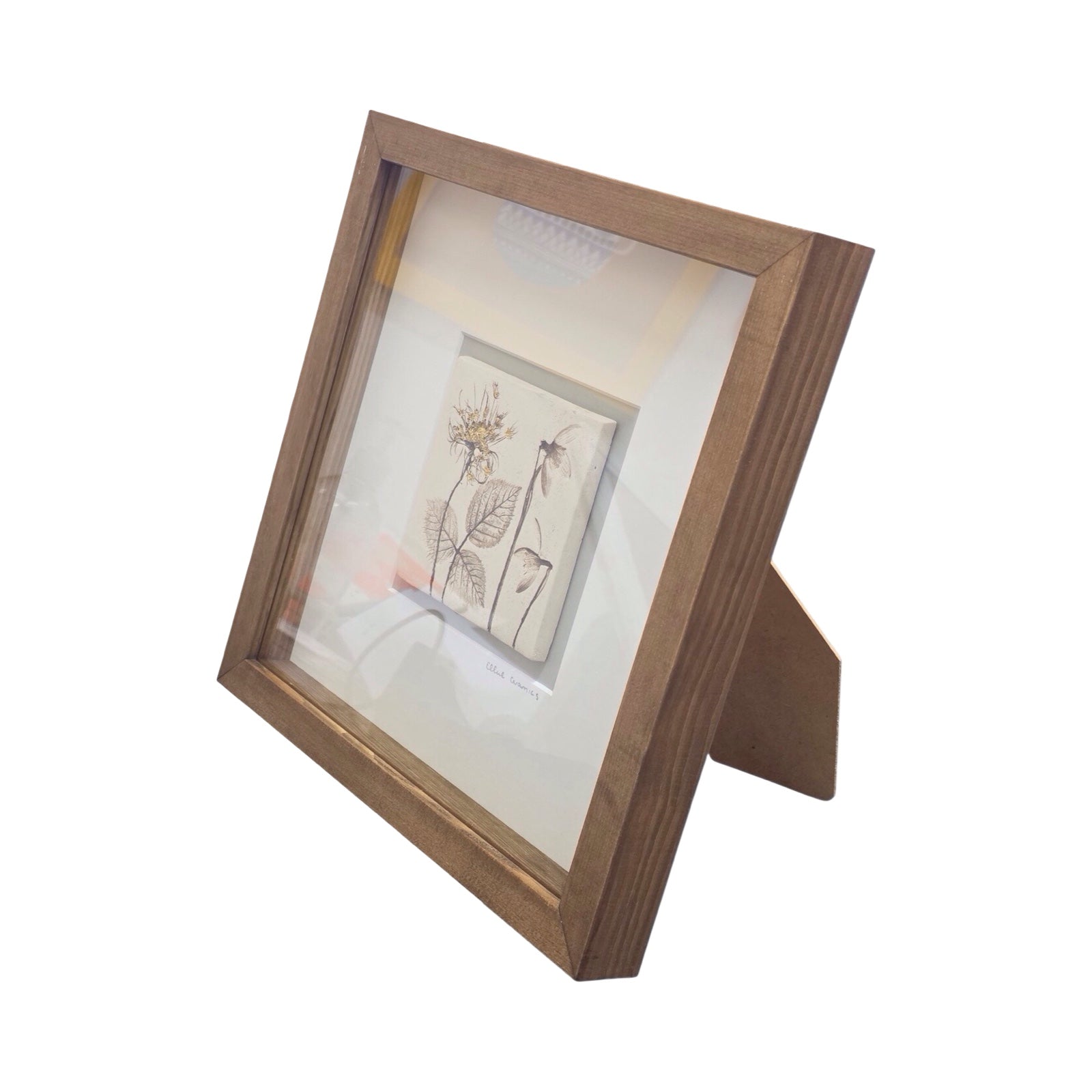 Framed single botanical tile with snowdrops and wild carrot in a oak frame on a white background