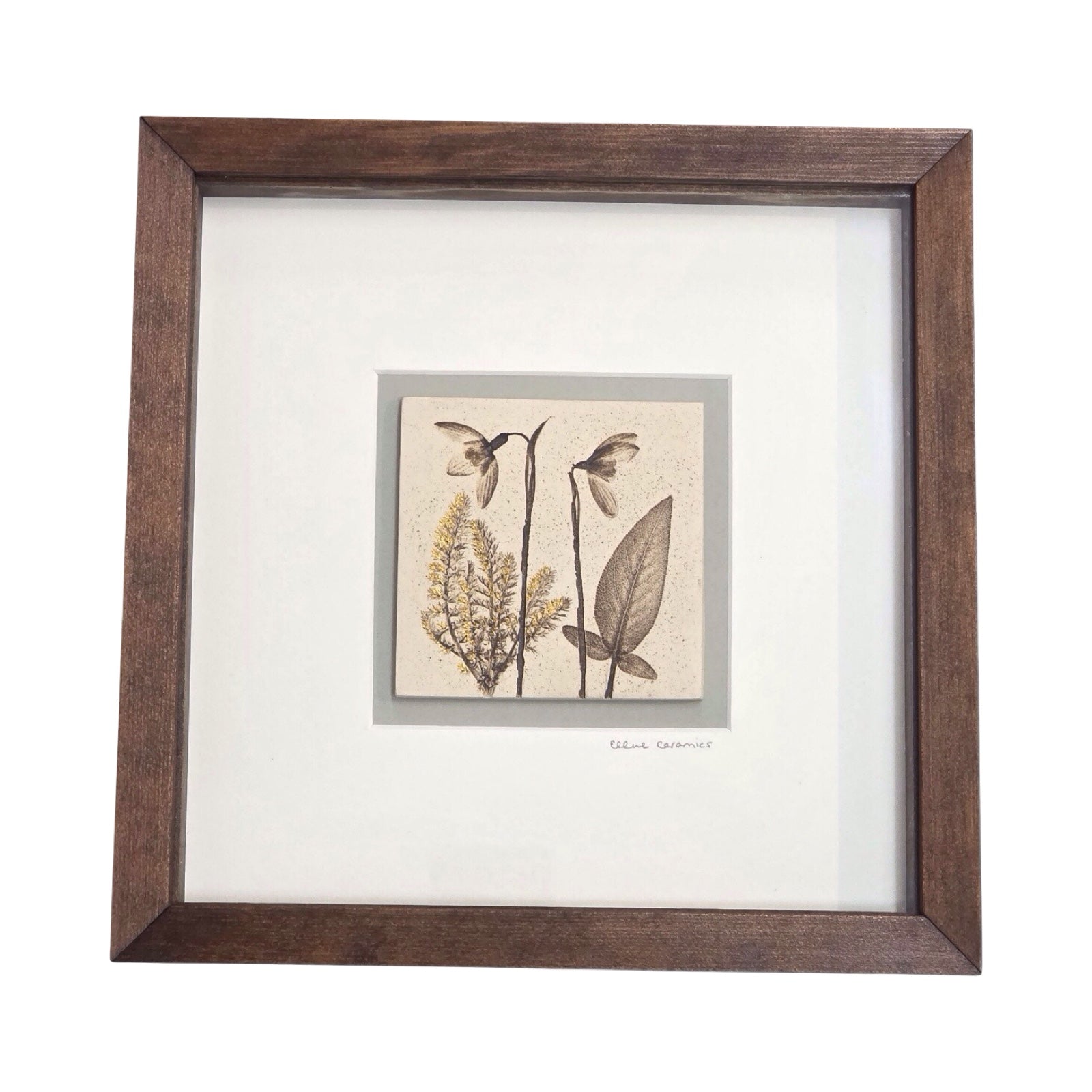 Framed botanical tile with a snowdrop in a wench wooden frame on a white background
