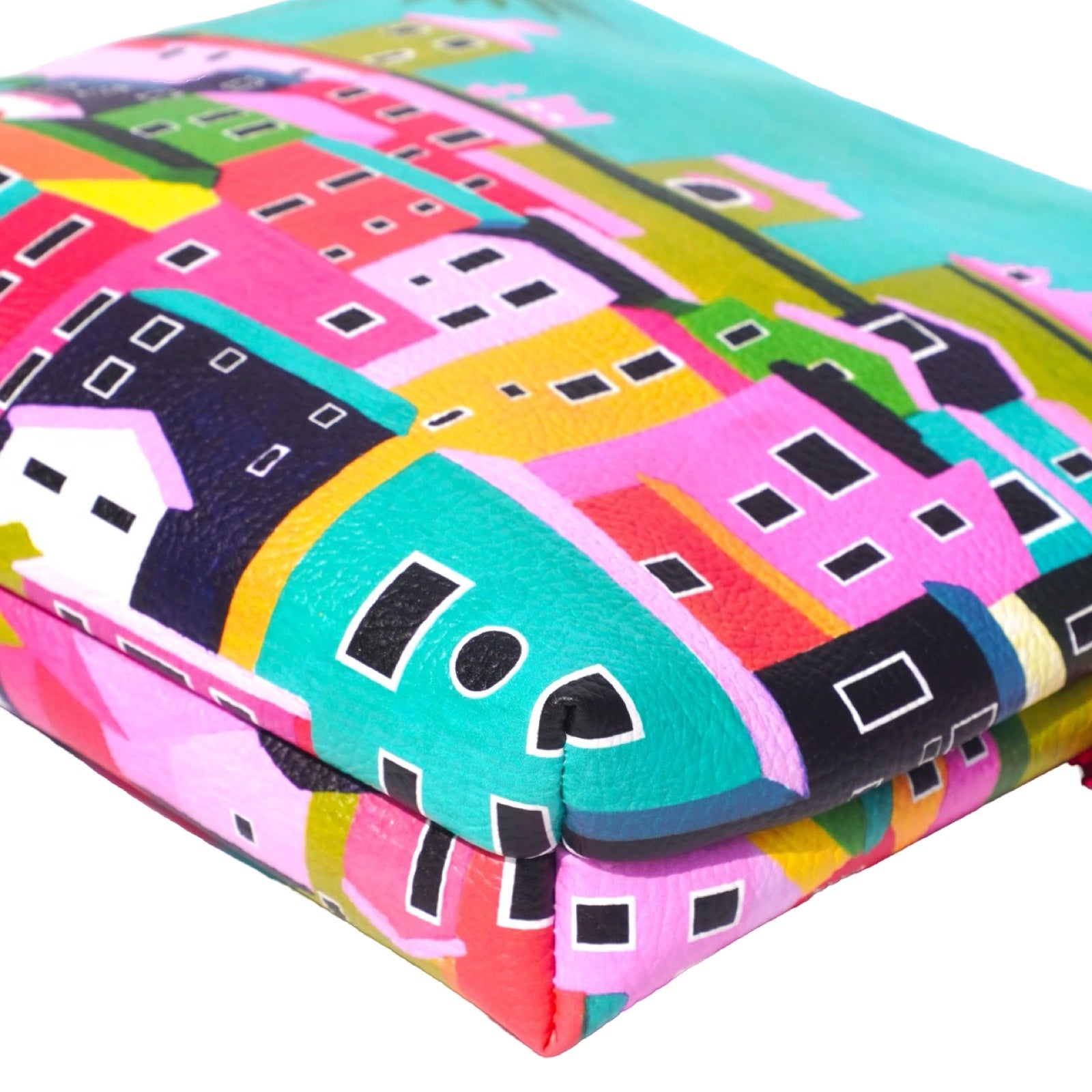 Vegan leather bag with a bright and colourful design of rooftops under a clear sky, and the bag is finished with a fabulous matching tassel on the end of the zip. 