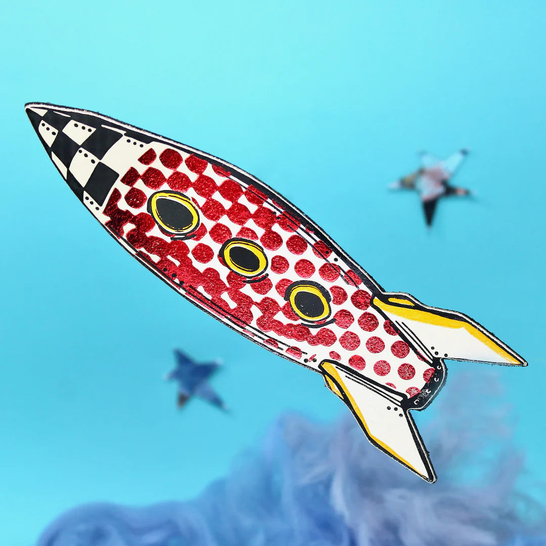 Decorative rocket bookmark with a red and white pattern on a blue background.