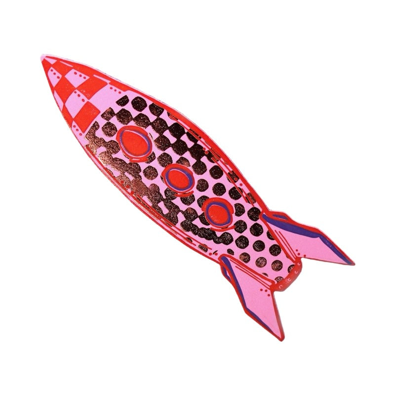 A pink space ship shaped bookmark with a red checked nose, red oval windows and gold embosses spots.