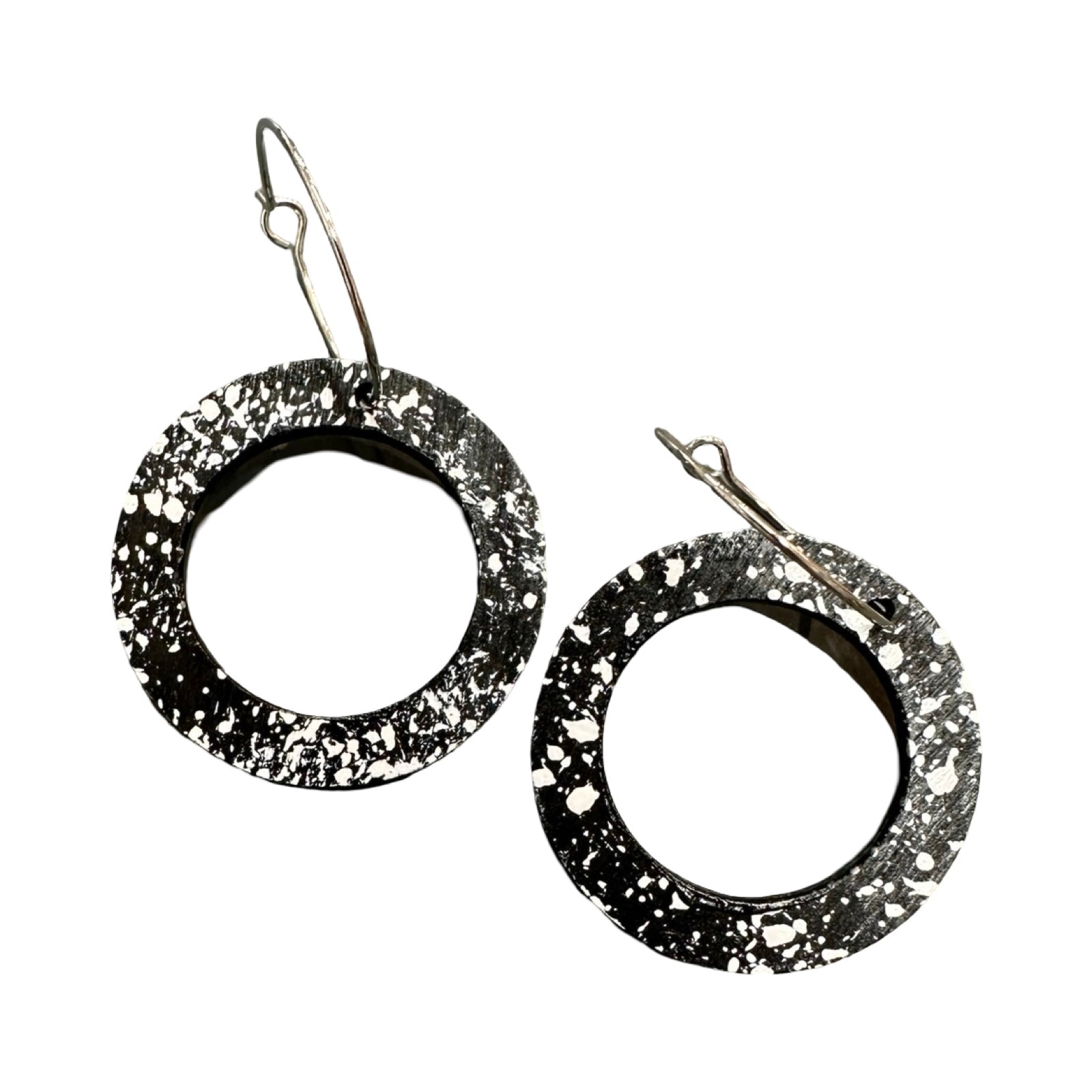 Black circular earrings with speckled texture on a white background.
