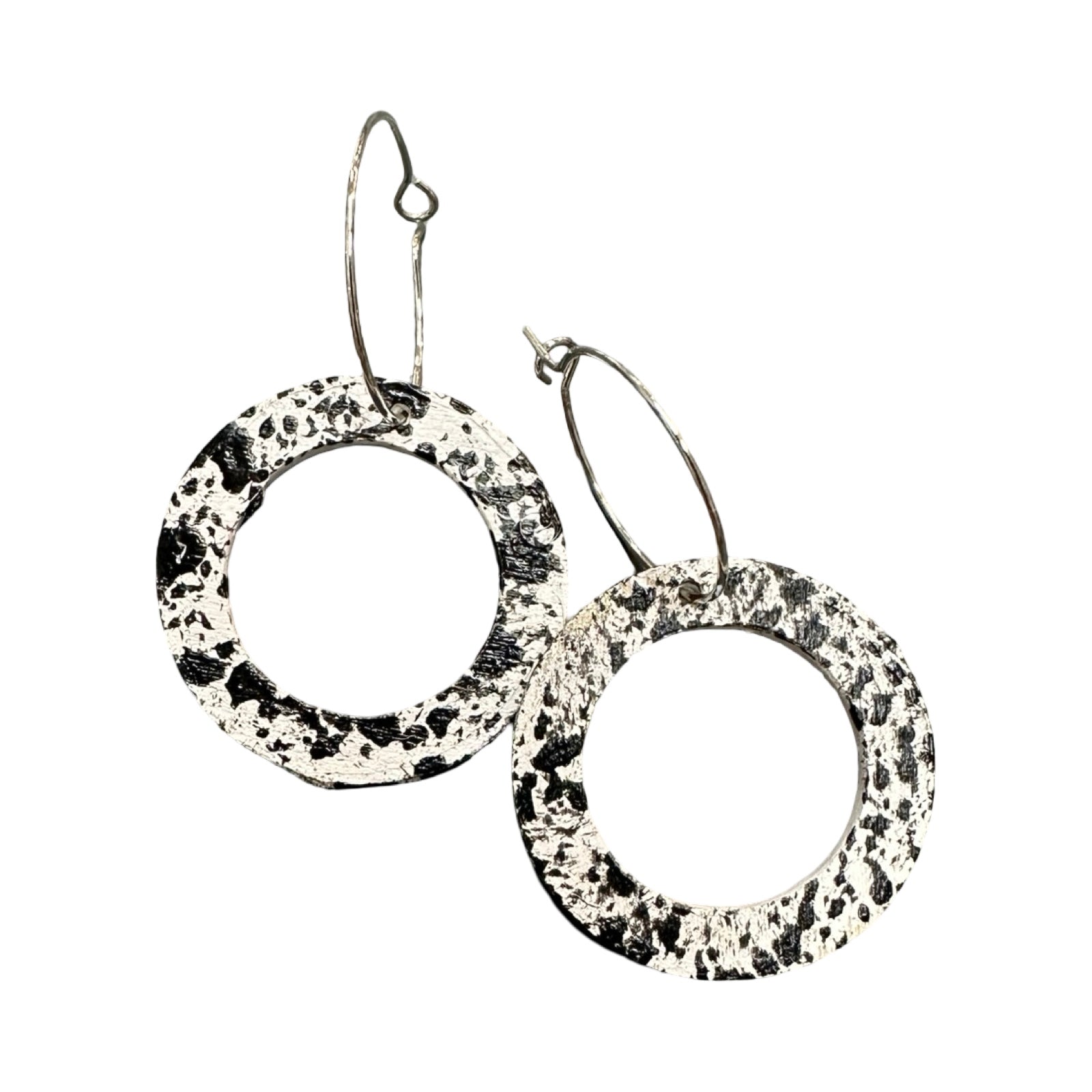Pair of hoop earrings with black and white speckled pattern on a white background.