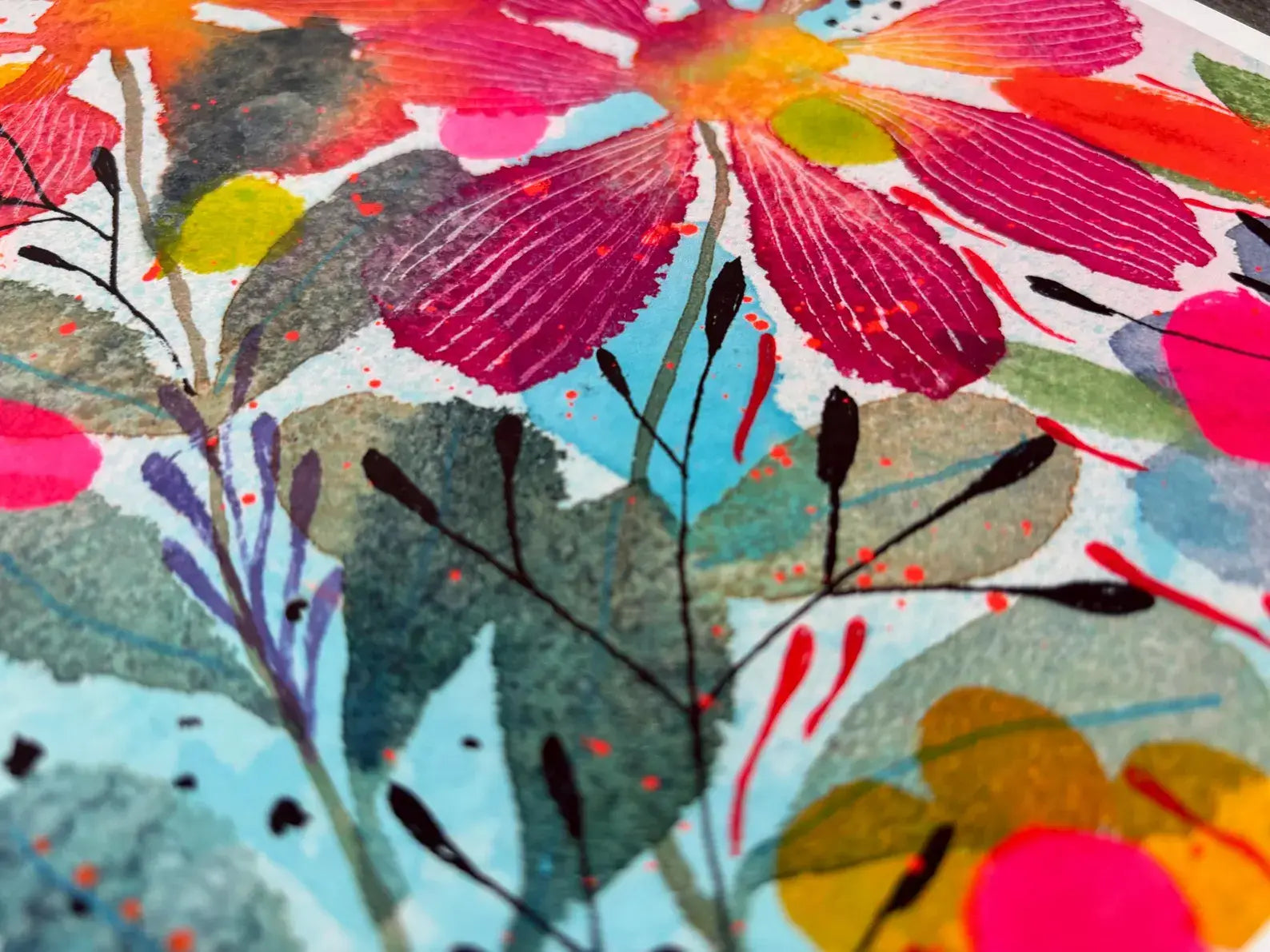 Colourful floral pattern with pink, red, and green flowers on a blue background