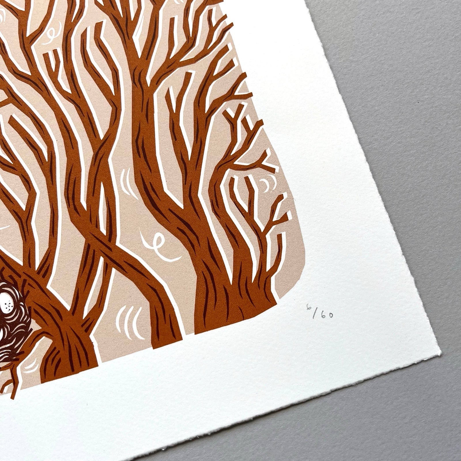 This squirrel screen print is printed in orange, red and peach. It features a squirrel playing in the treetops with a bird's nest resting below, and is printed on hand-torn, thick, satin white paper. 