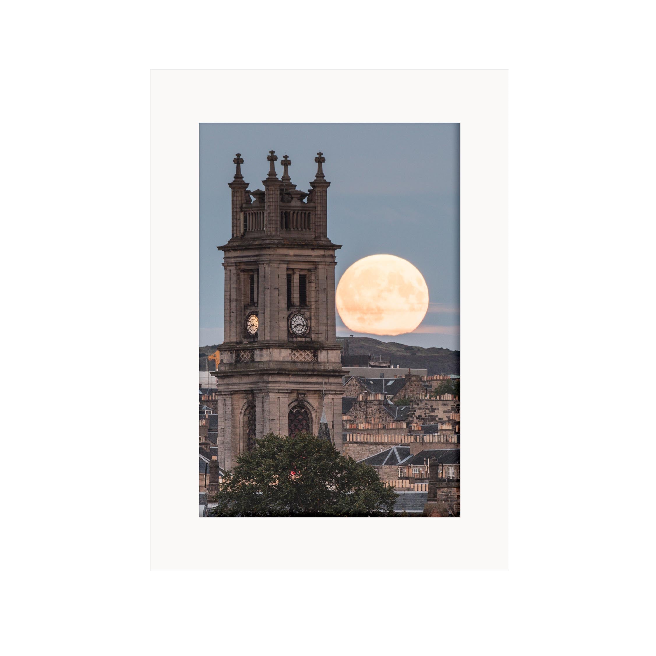 An image of the moon rising behind a St Stephen's Church Edinburgh. 