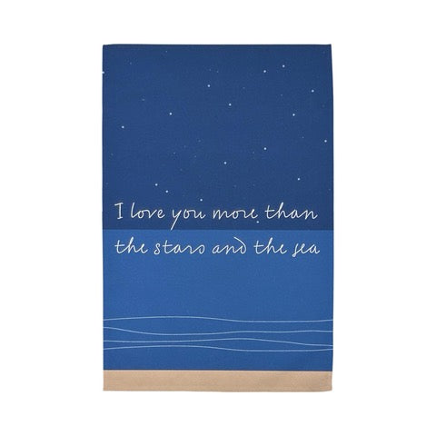 Tea towel featuring a starry night sky above the sea and the text 'I Love You More than the Stars and the Sea'. 