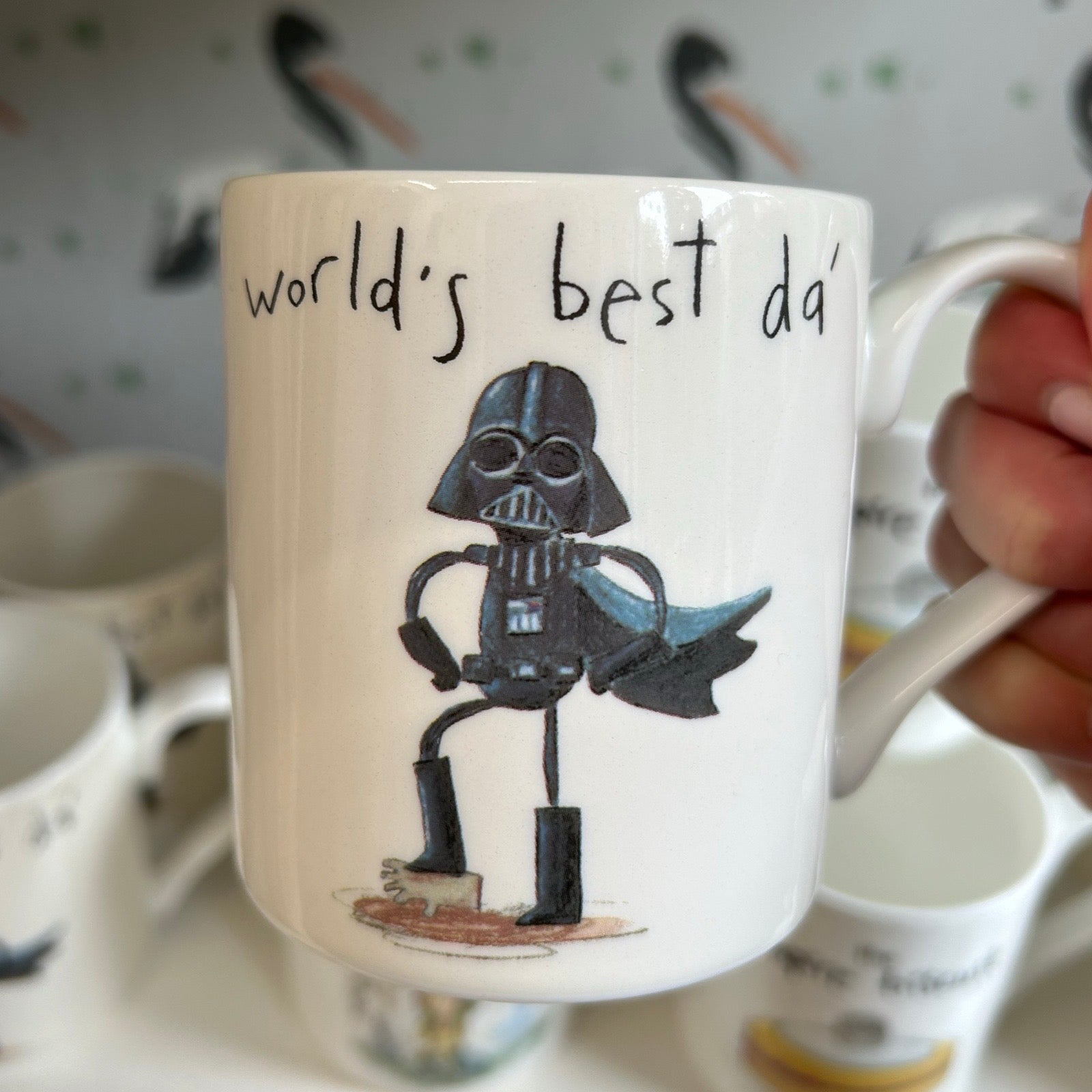Mug with Darth Vader illustration and 'world's best dad' text held by a hand.
