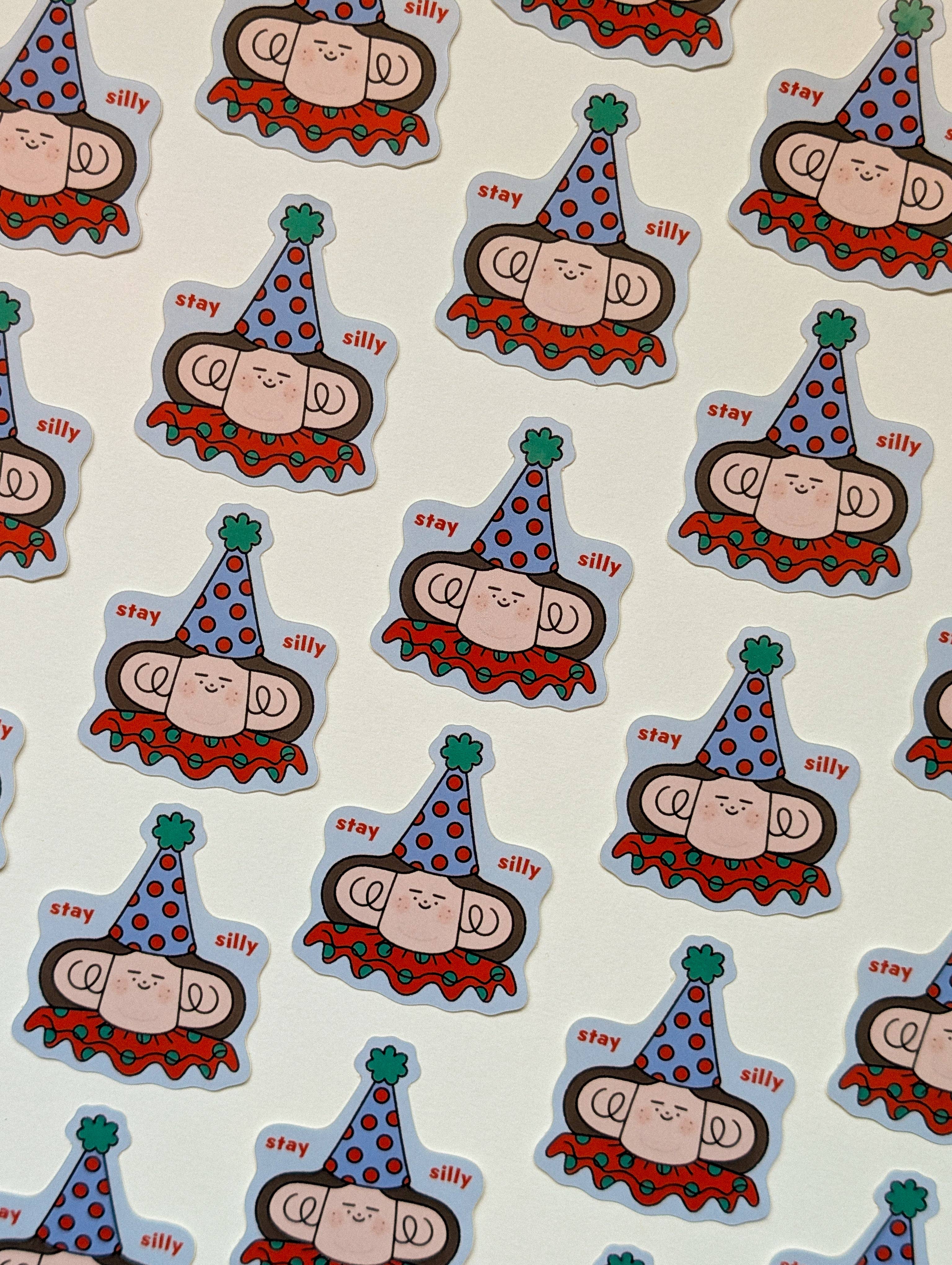 A repeating pattern of cartoon person stickers wearing party hats, shown on a white background.