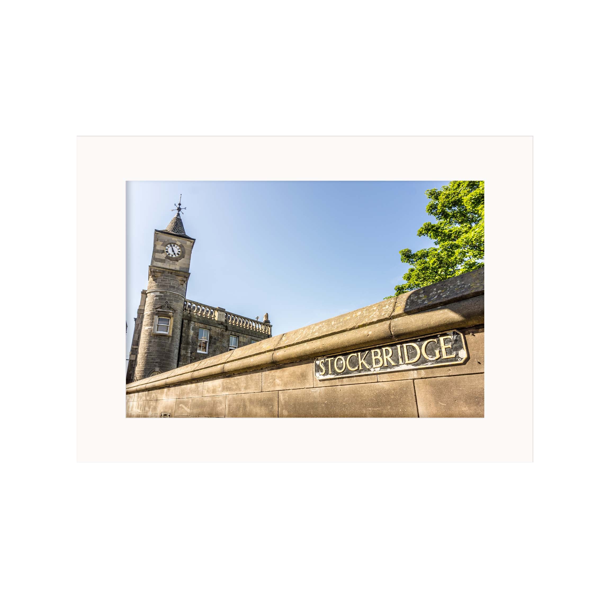 Clock tower with 'Stockbridge' sign against a blue sky
