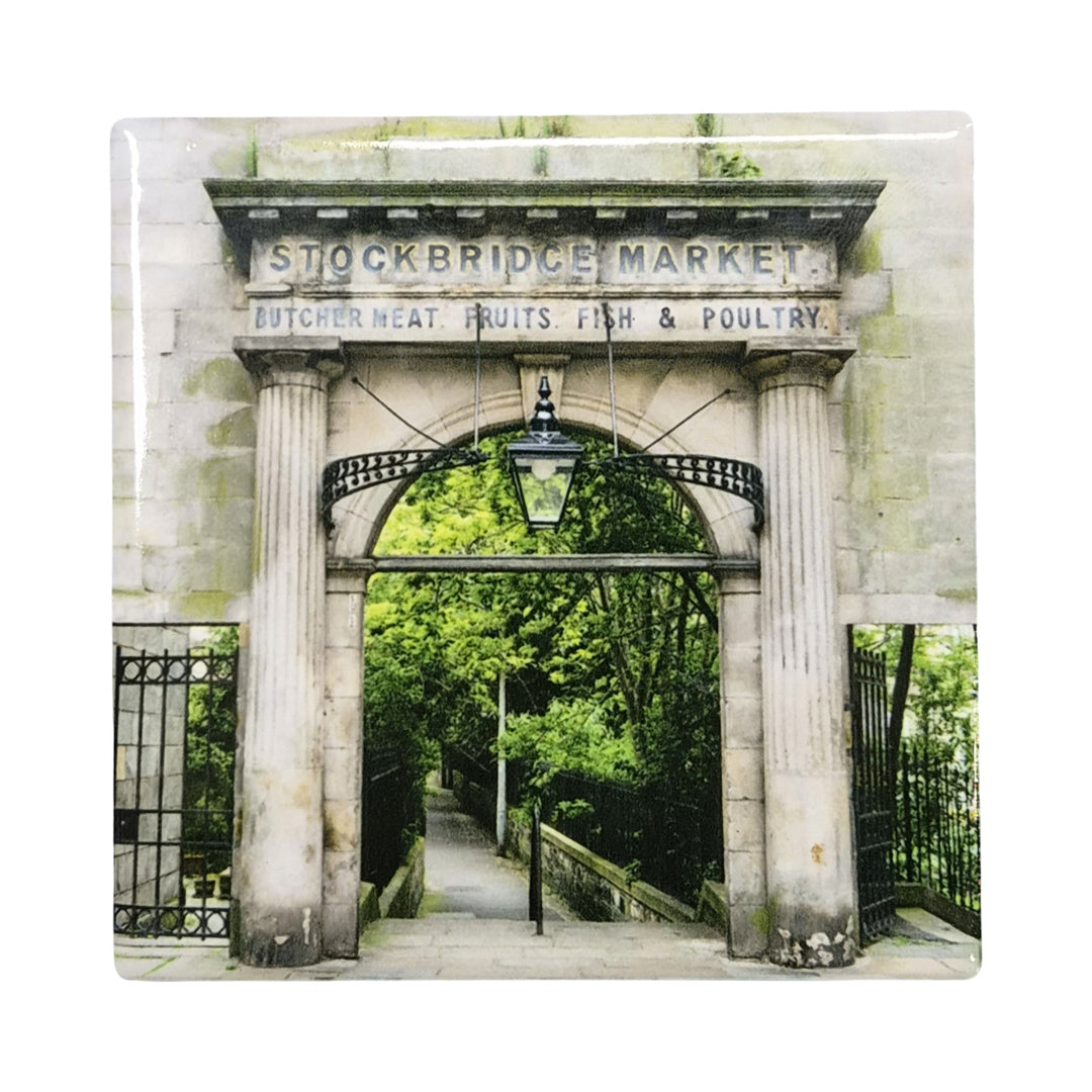 Stone archway with 'Stockbridge Market' sign and greenery beyond
