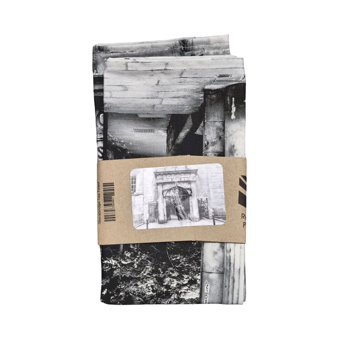 A folded tea towel with a cardboard sleeve. 