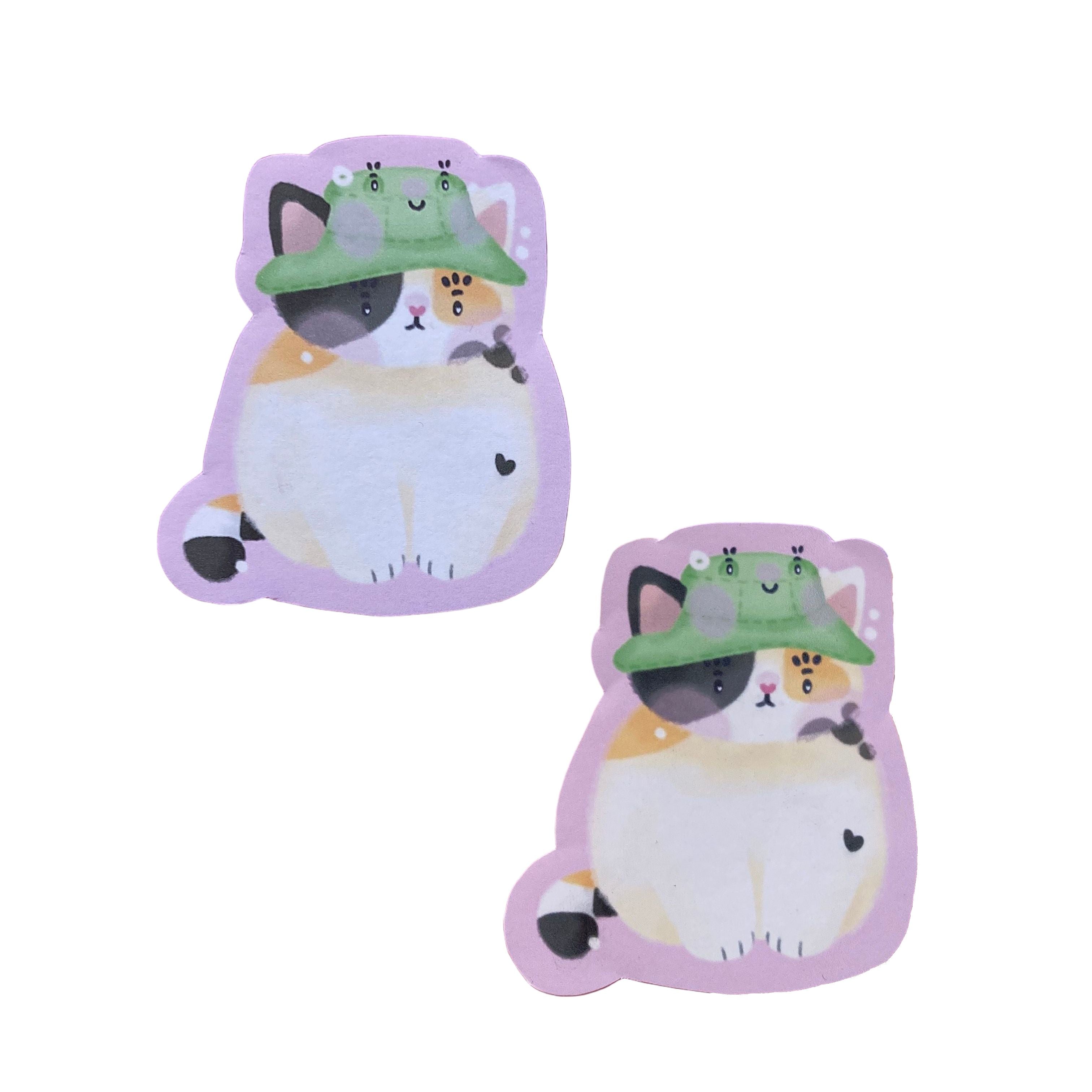 Handmade vinyl sticker of Bucket the calico cat, looking stressed and existential. Made from recyclable vinyl sticker paper. Sticker is scratchproof and weatherproof.

In the second photo, the matte sticker is at the top, and the glossy sticker is at the bottom.