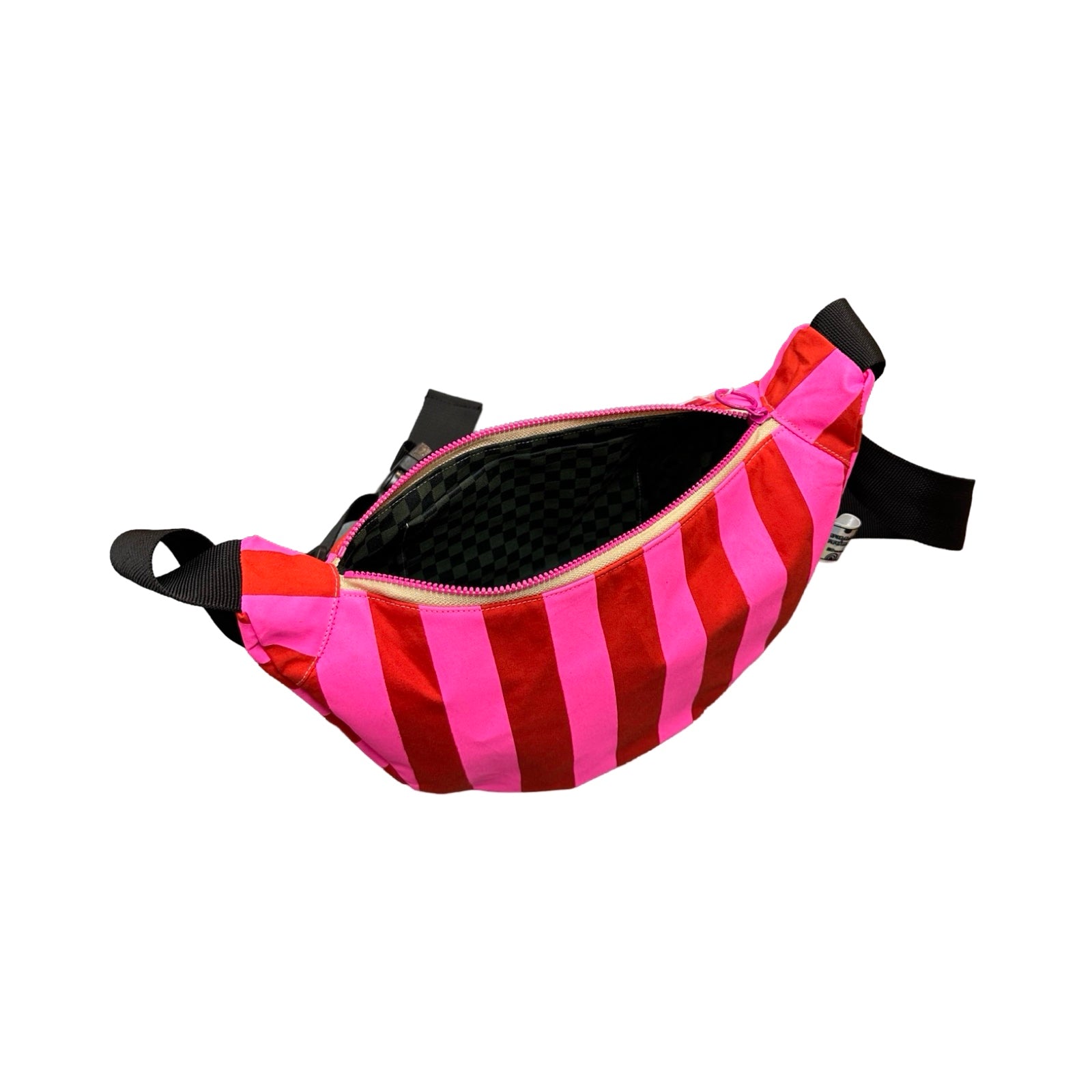 A pink and red striped sling bag open to show balck and grey checked lining fabric.
