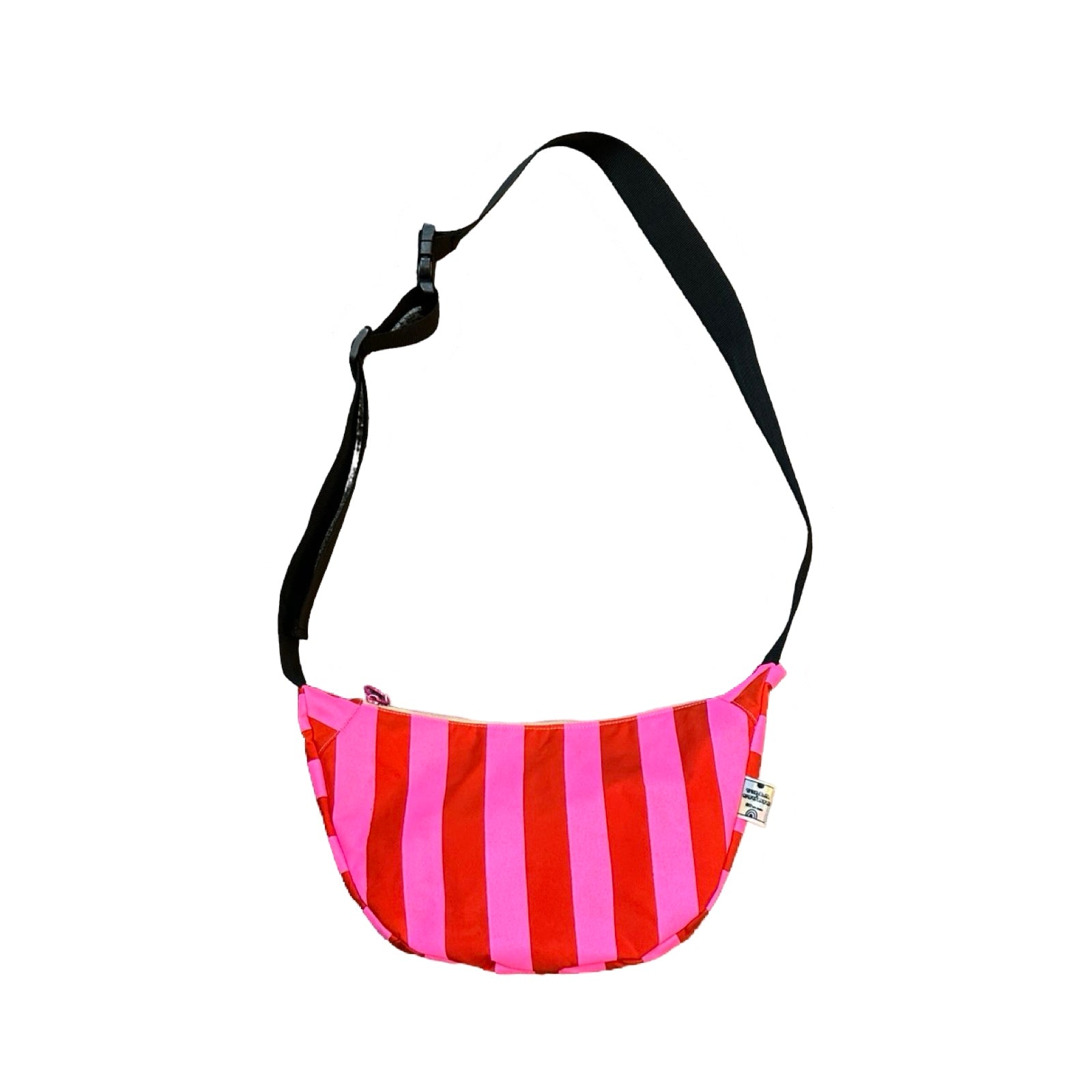 A pink and red striped sling bag with a black adjustable strap.
