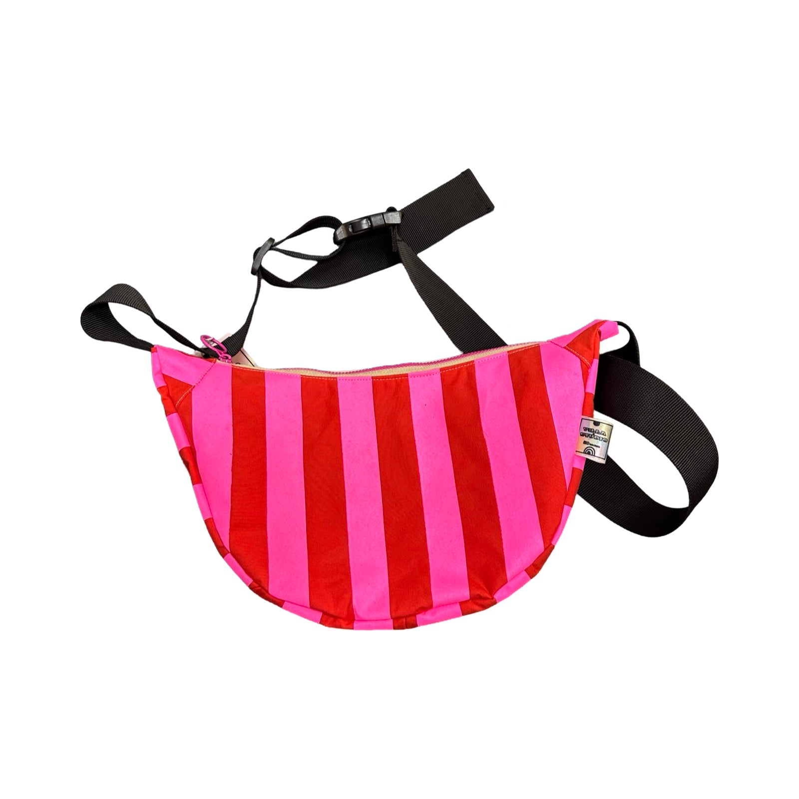 A pink and red striped sling bag with a black adjustable strap.