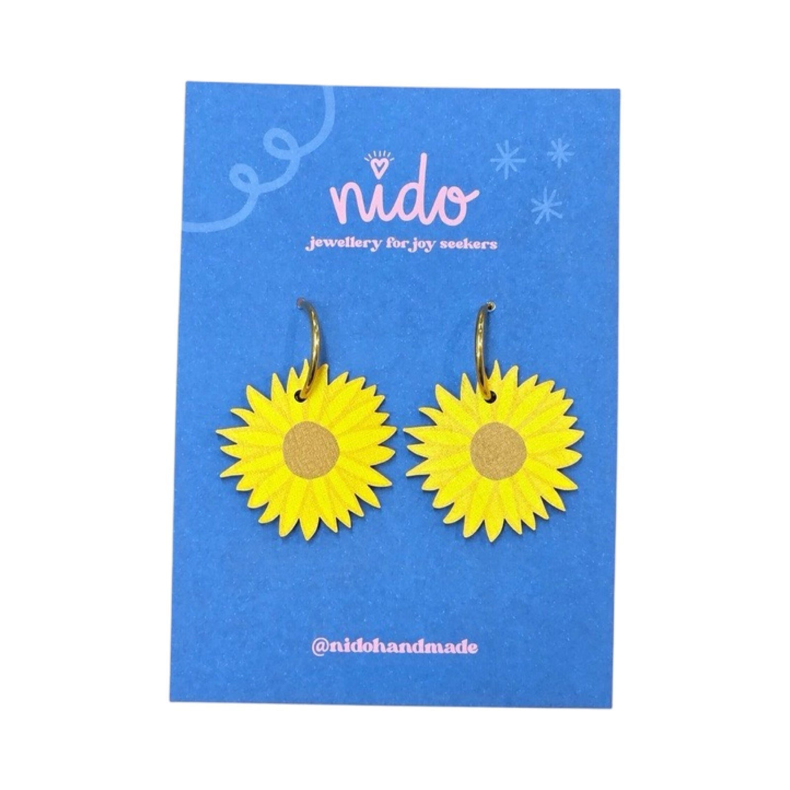 These wooden sunflower-shaped earrings feature yellow and orange petals with a brown centre., presented on a branded blue backing card.