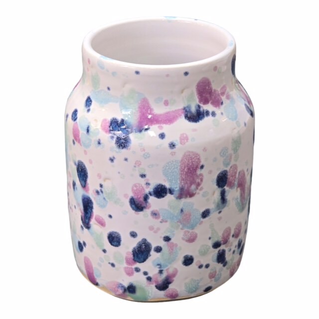 Sweet pea ceramic vase with pink, navy and turquoise shapes against a white background.