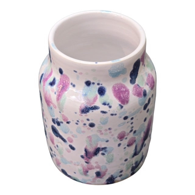 Sweet pea ceramic vase with pink, navy and turquoise shapes against a white background.