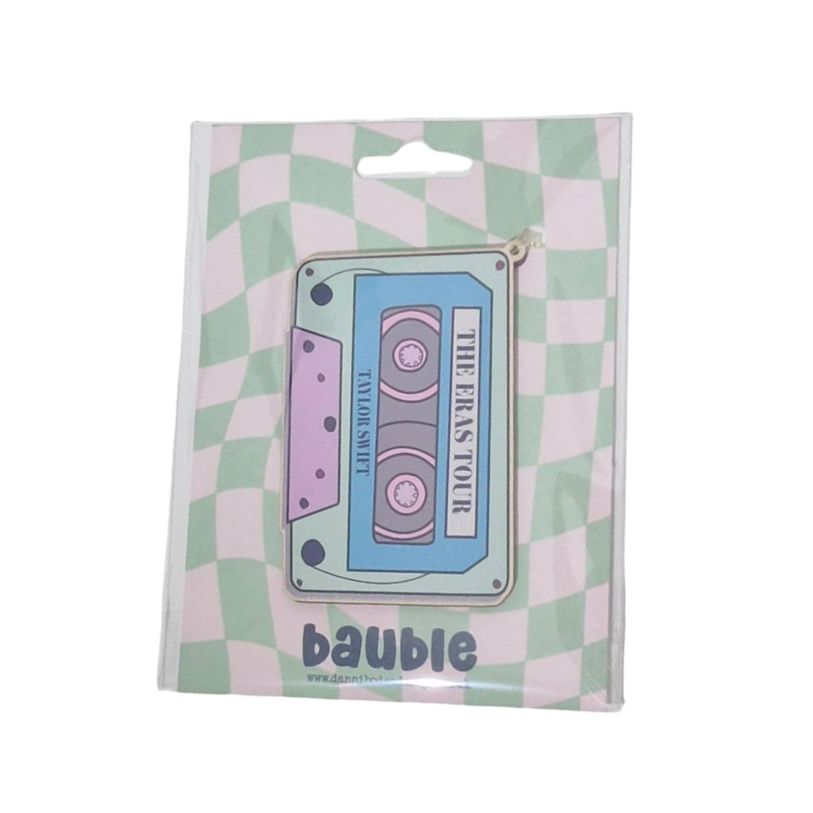 A rectangular-shaped wooden decoration featuring an illustration of a retro cassette tape in blue, pink and aqua with the title 'The Eras Tour, Taylor Swift'. 