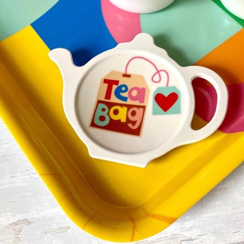 White melamine tea bag holder in the shape of a teapot with an illustration of a tea bag and the text 'Tea Bag'.