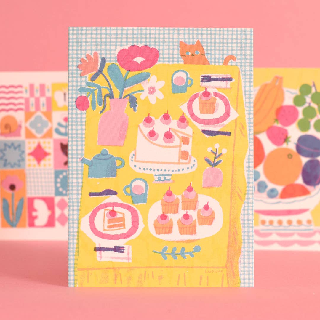 Colorful tea party-themed fabric with patterns on a pink background.