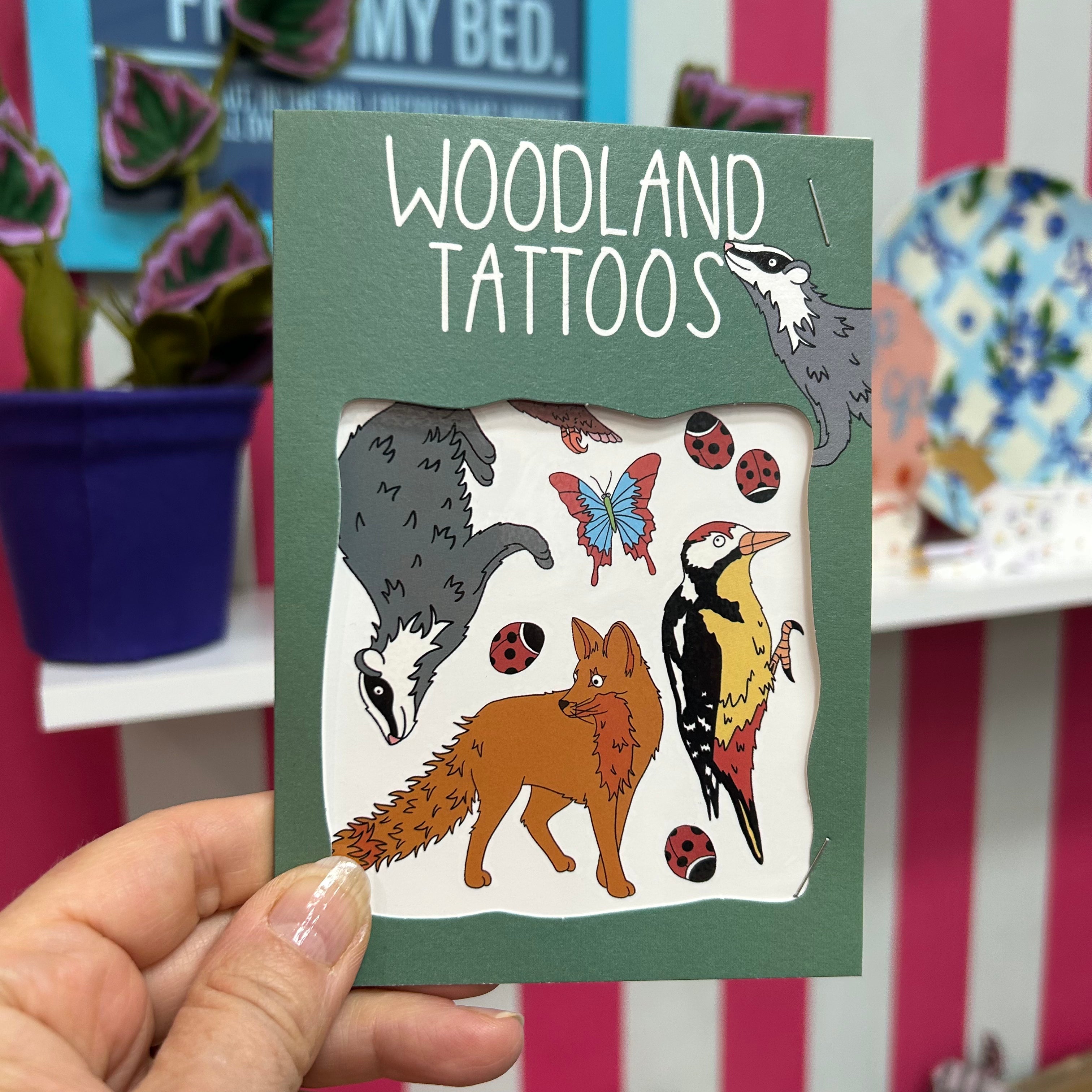 Hand held set of woodland temporary tattoos featuring fox, badger, woodpecker and insects.