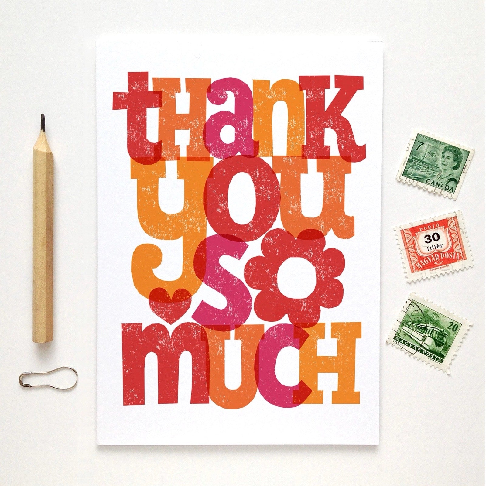 Colorful 'Thank you so much' card with stamps and a pencil on a white background.