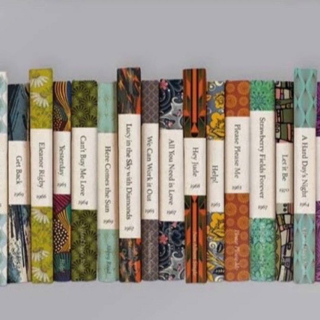 Row of books with colourful covers on a grey background.