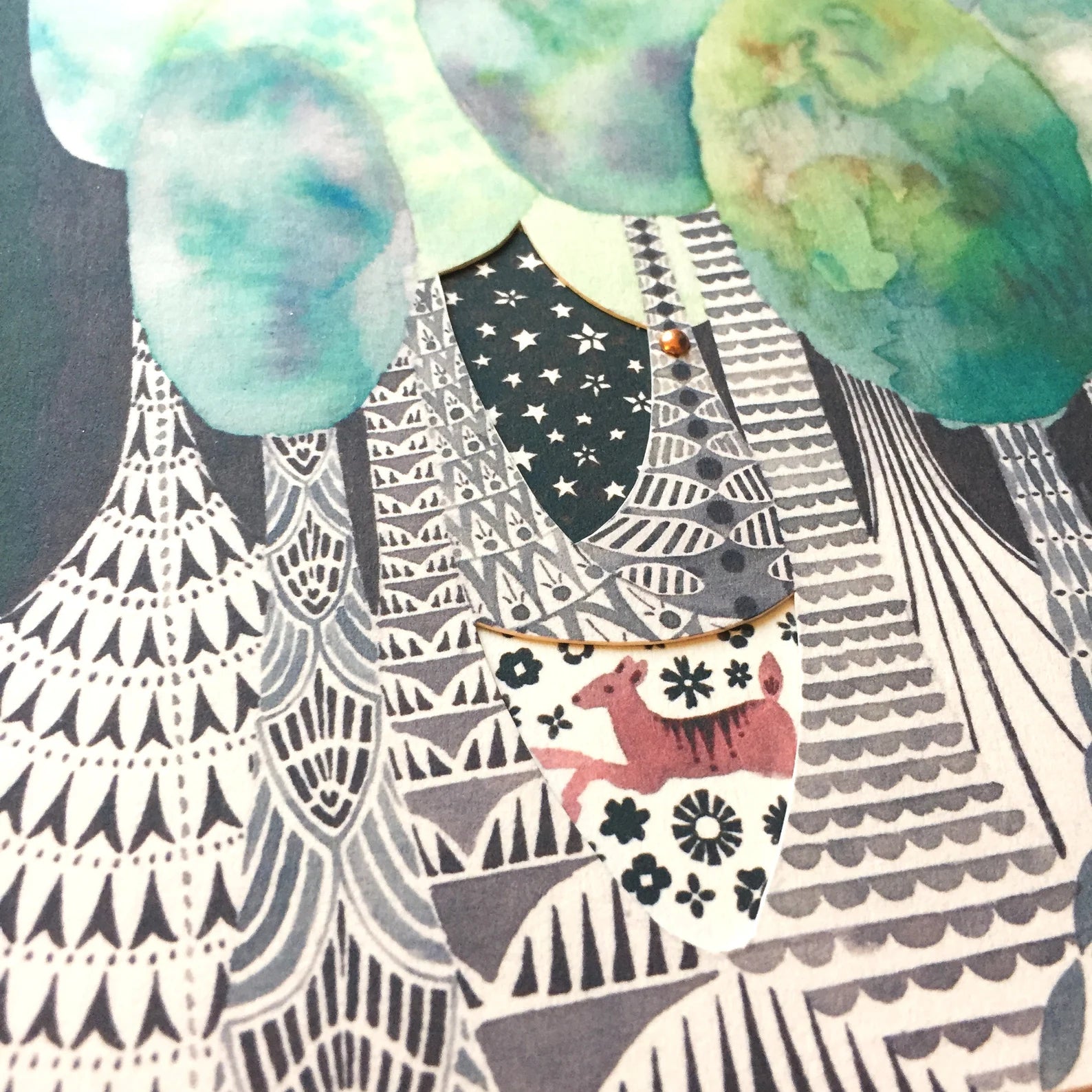 Close-up of a patterned notebook with trees and a deer illustration.