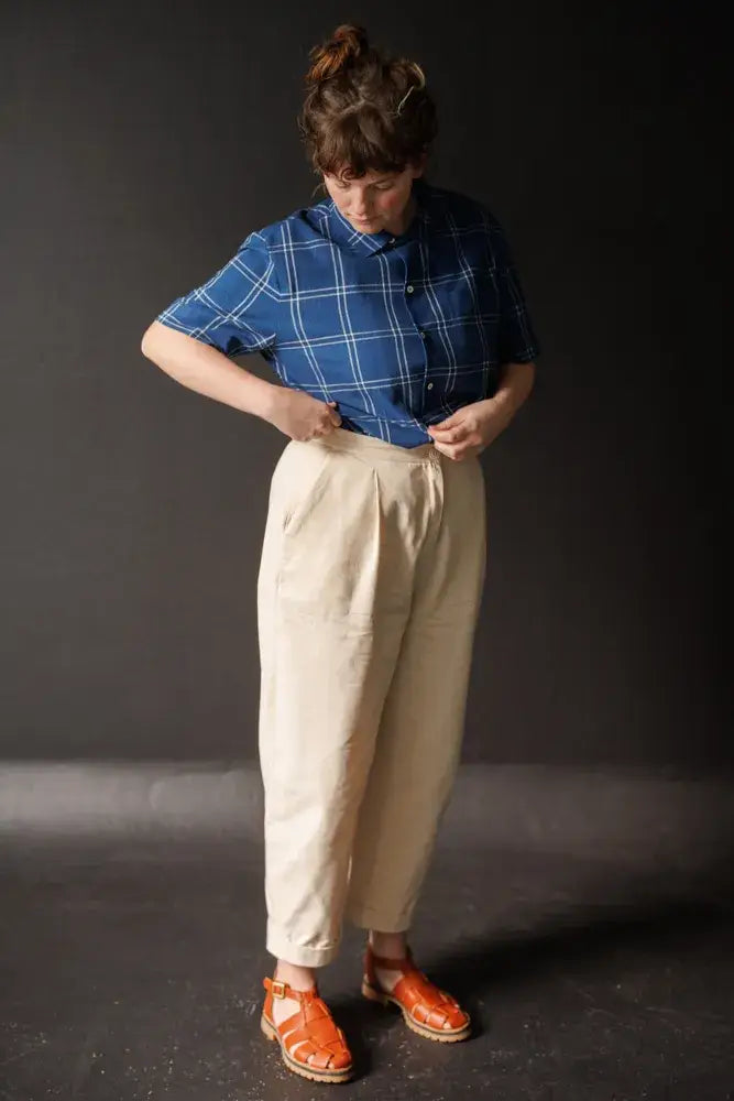 Sewing pattern for a pair of 'peg' trousers featuring a fly front, angled pockets and turn-ups. 