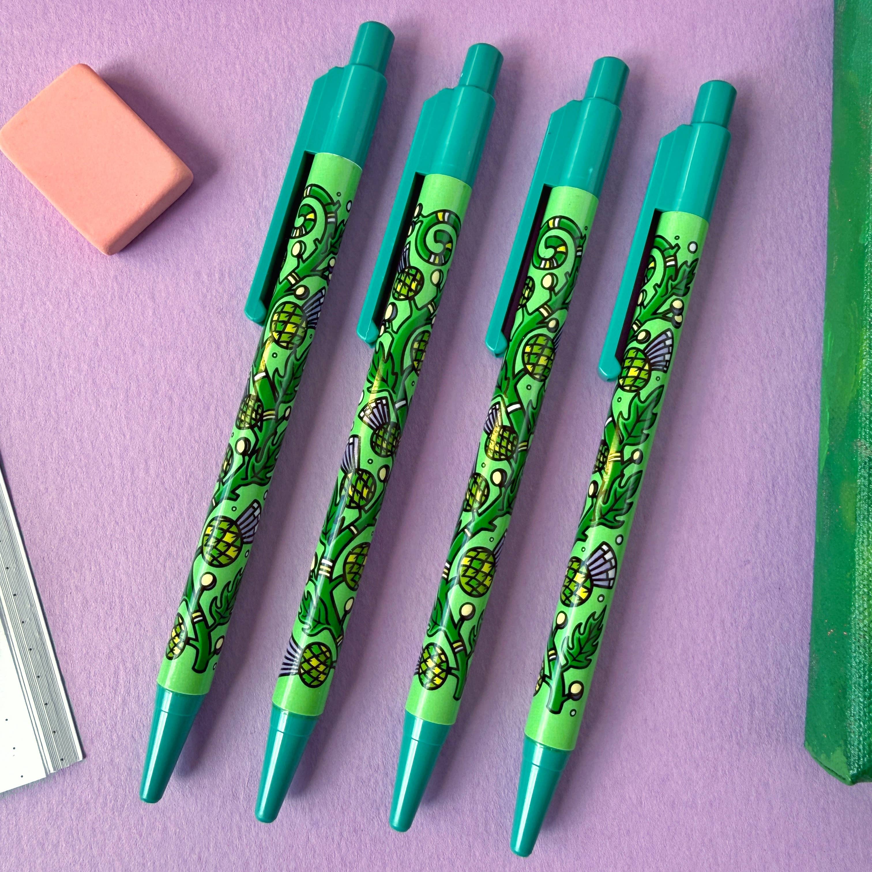 Four green pens with thistle design on a purple background.