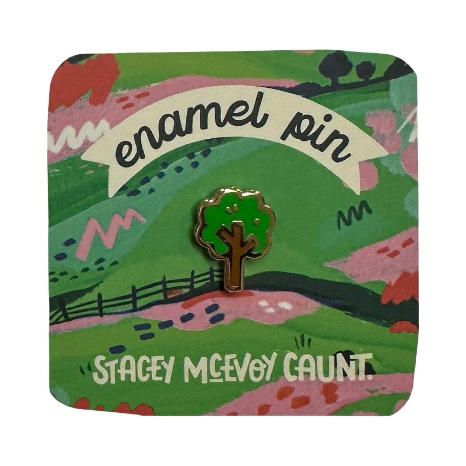 Enamel pin with a tree design on a colourful card featuring 'Stacey McEvoy Caunt'.