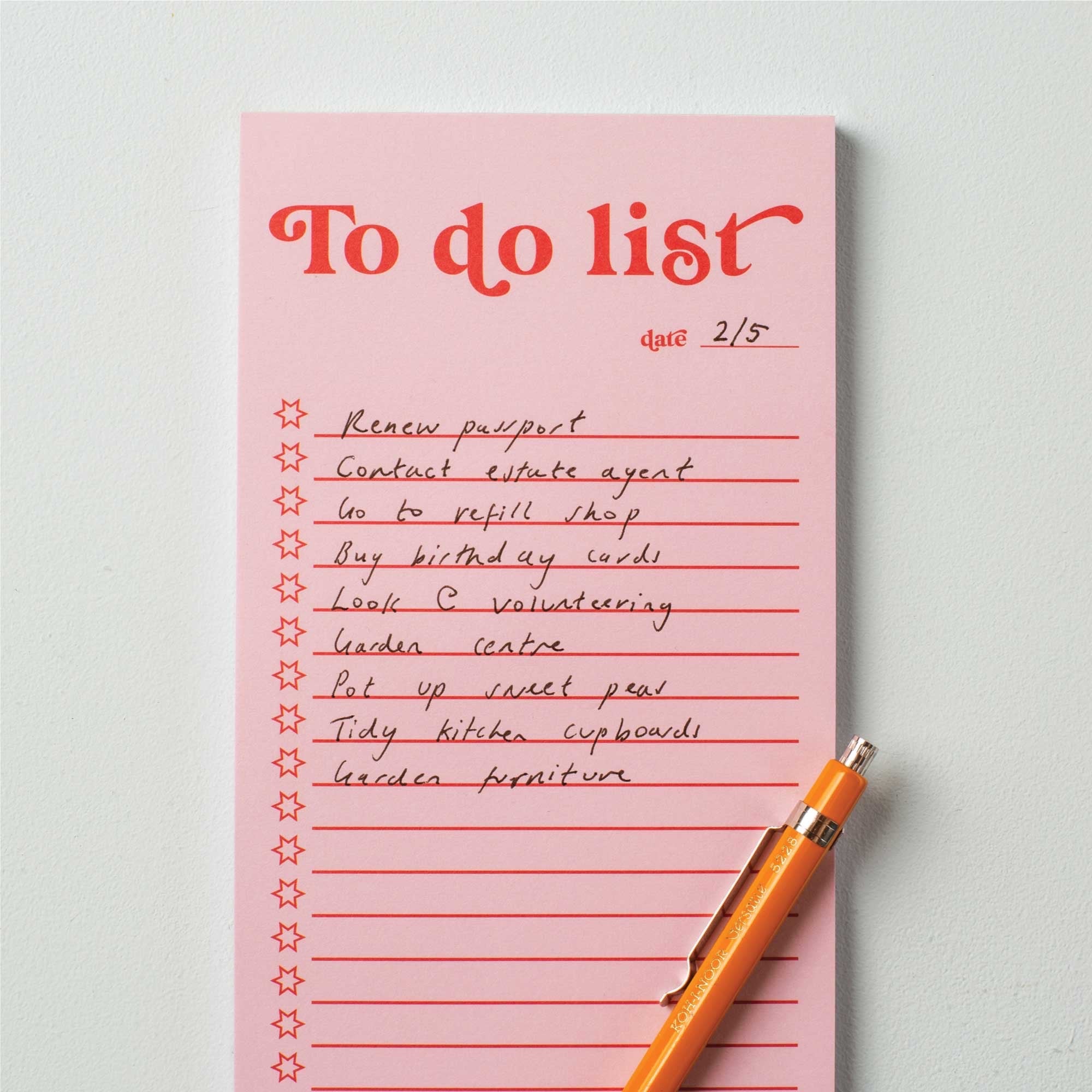 Pink to-do list with handwritten tasks and an orange pen on a light grey background.