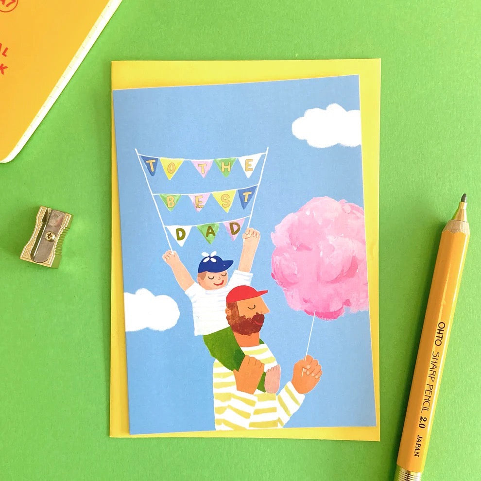 Greeting card with illustration of a father and son holding cotton candy and a banner on a green background with a pencil and sharpener.