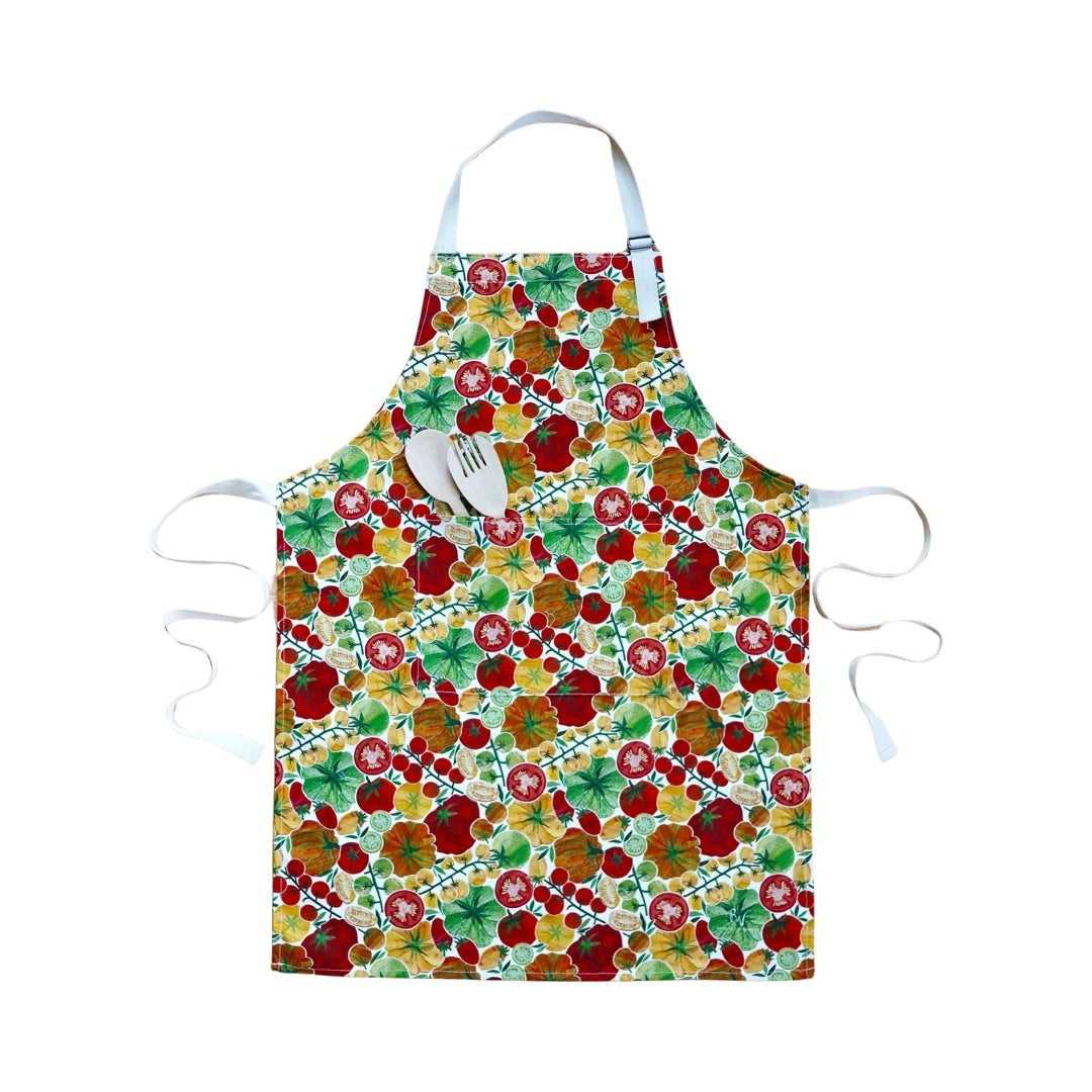 Apron featuring red, orange and yellow tomatoes with green foliage on a white background.