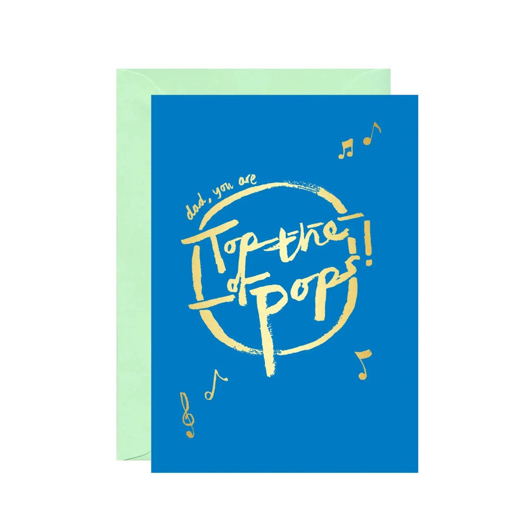 Card featuring the text 'Dad you are top of the pops' in gold lettering against a blue background with a pale green envelope