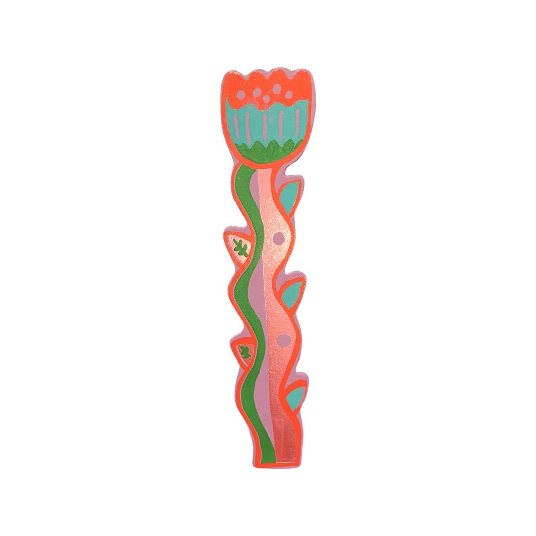 A tulip shaped leather bookmark with a red outline, a red, turquoise and green flower and a green, lilac and gold stem.