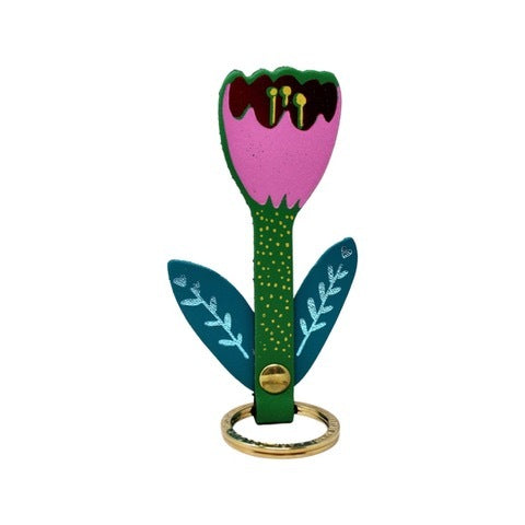 A tulip shaped leather keyring with a pink and red flower. a green stem and teal leaves with turquoise detail on a gold plated ring.