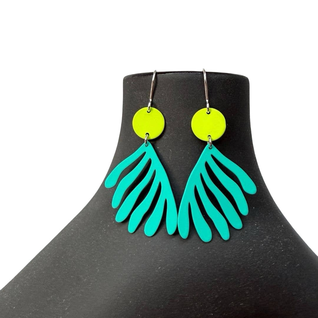 Green leaf-shaped earrings on a black mannequin.