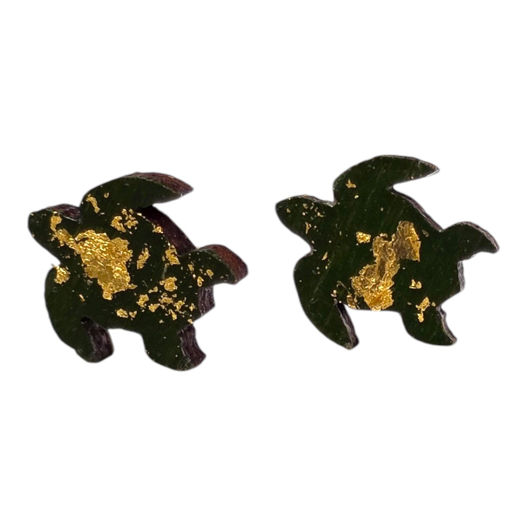 An image of small wooden earrings shaped as turtles.