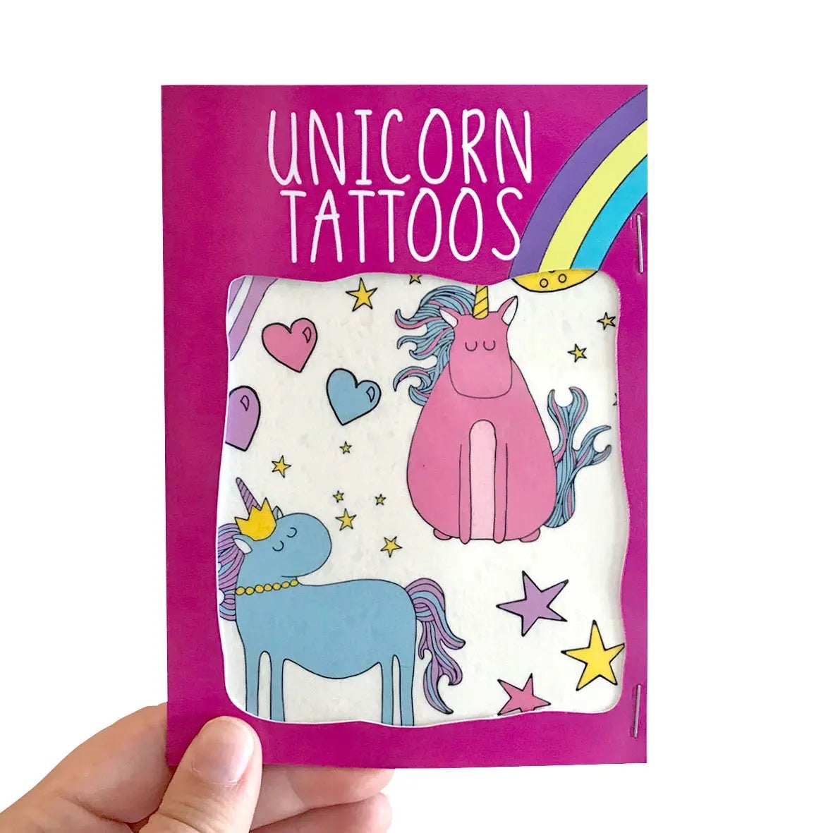 Set of unicorn-themed transfer tattoos featuring pink and blue unicorns and love hearts, being held by a hand.